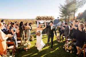 Scenic outdoor wedding ceremony at Milea Estate Vineyard with rolling hills and vineyards in the background